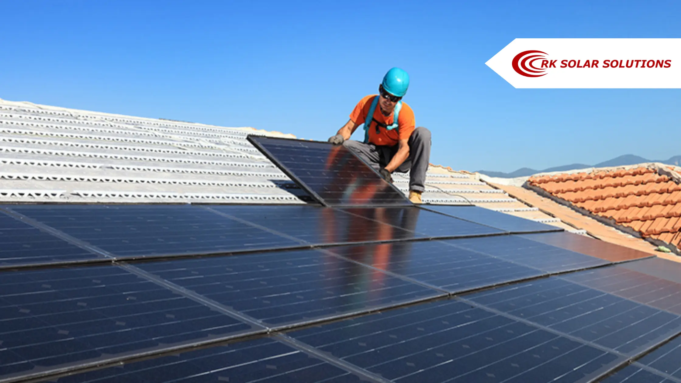 Technician fitting a solar panel on a tiled roof