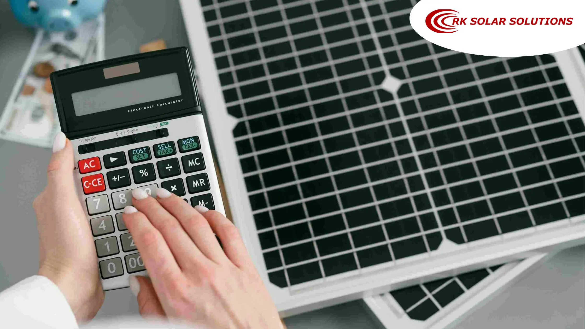 Hand using a calculator next to a solar panel