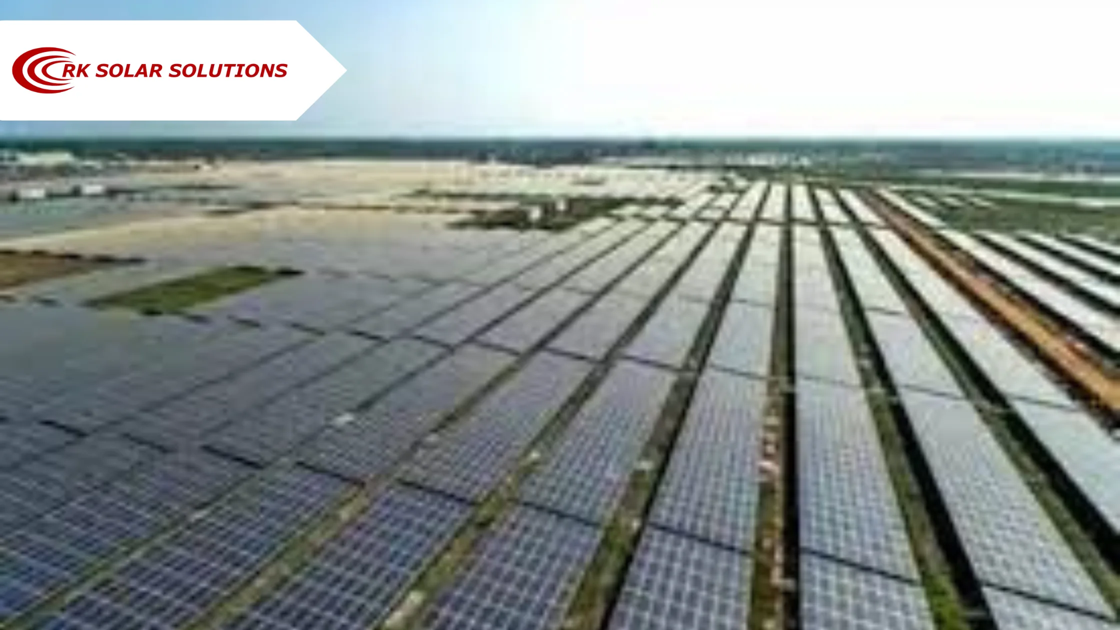 Aerial view of a large solar power plant with long rows of panels